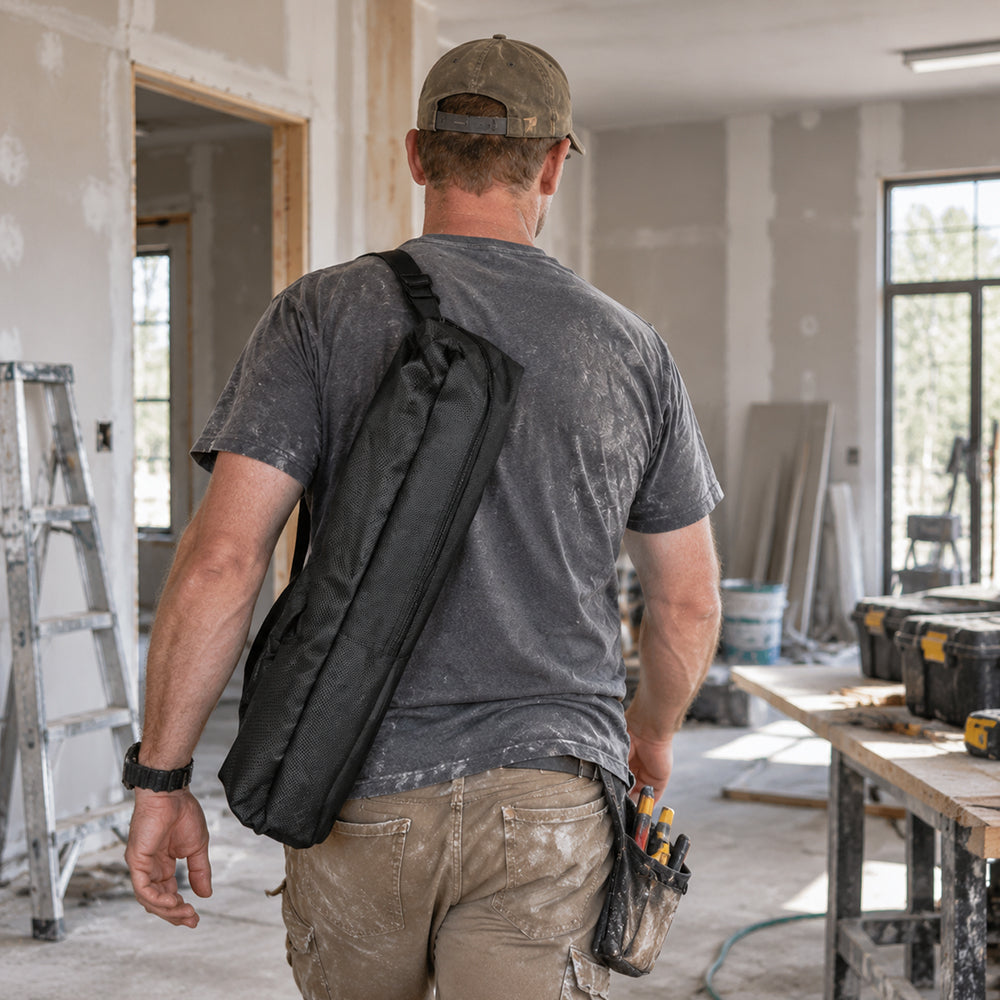 Huepar black crossbody tool bag carried by a man at a construction site.
